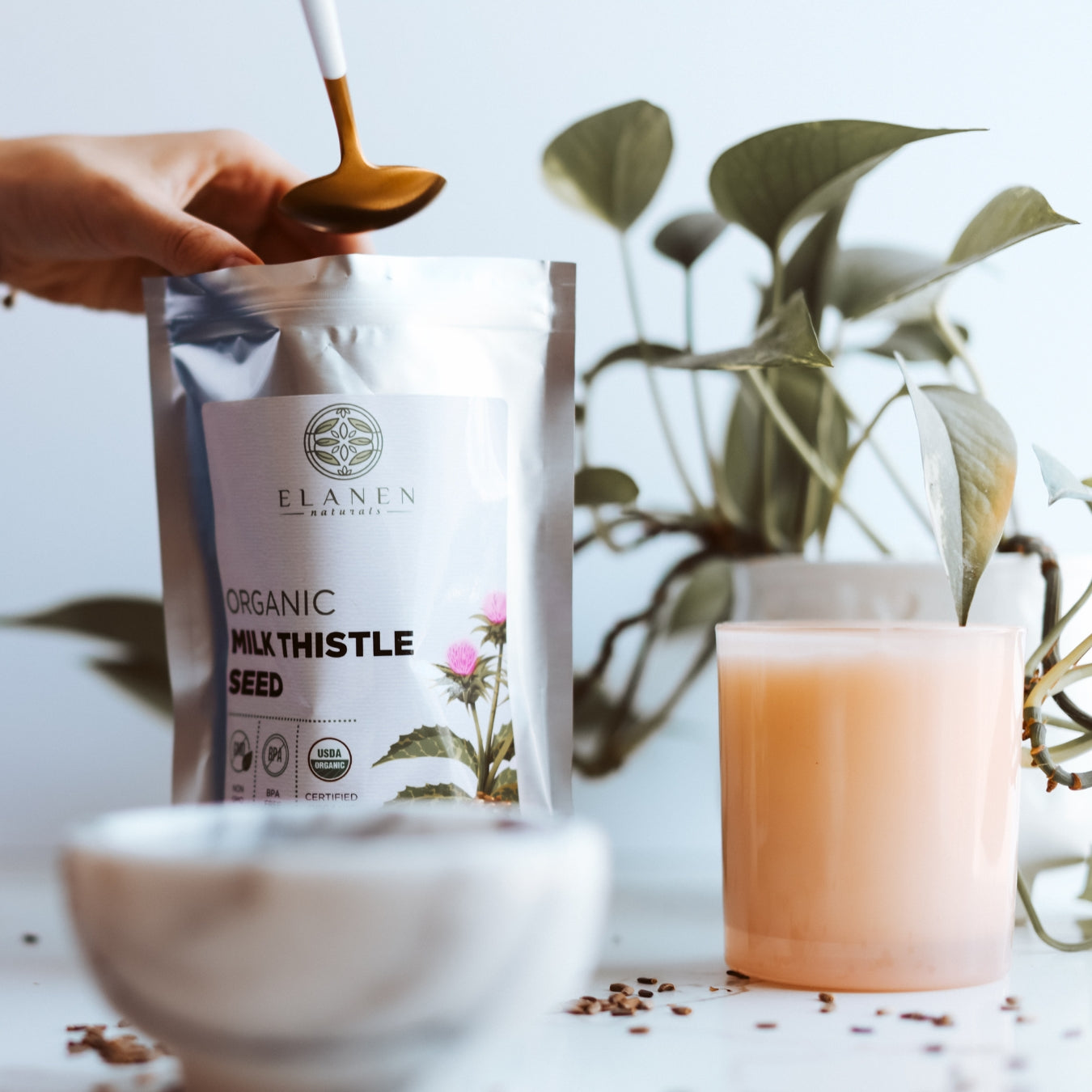 Elanen Organic Milk Thistle Seed package with a spoon, bowl, and plant in the background