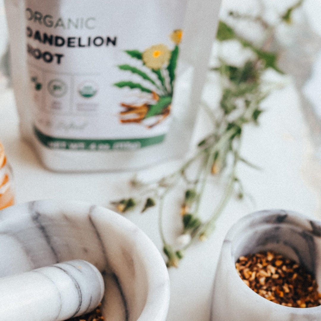Tea packaging labeled 'Organic Dandelion Root' with a white teapot and mortar and pestle in the background.