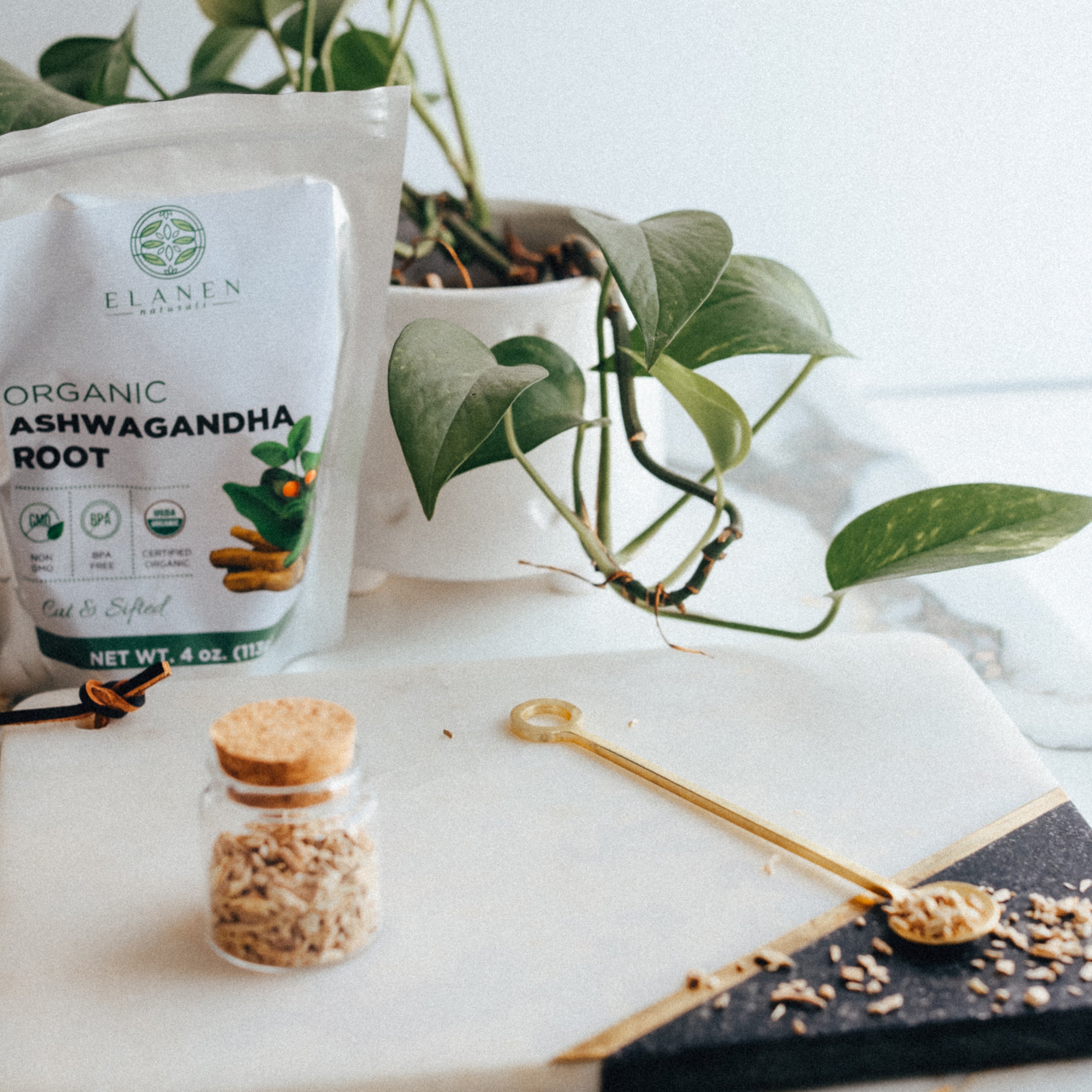 Elanen Organic Ashwagandha Root packaging on a marble surface with a plant in the background
