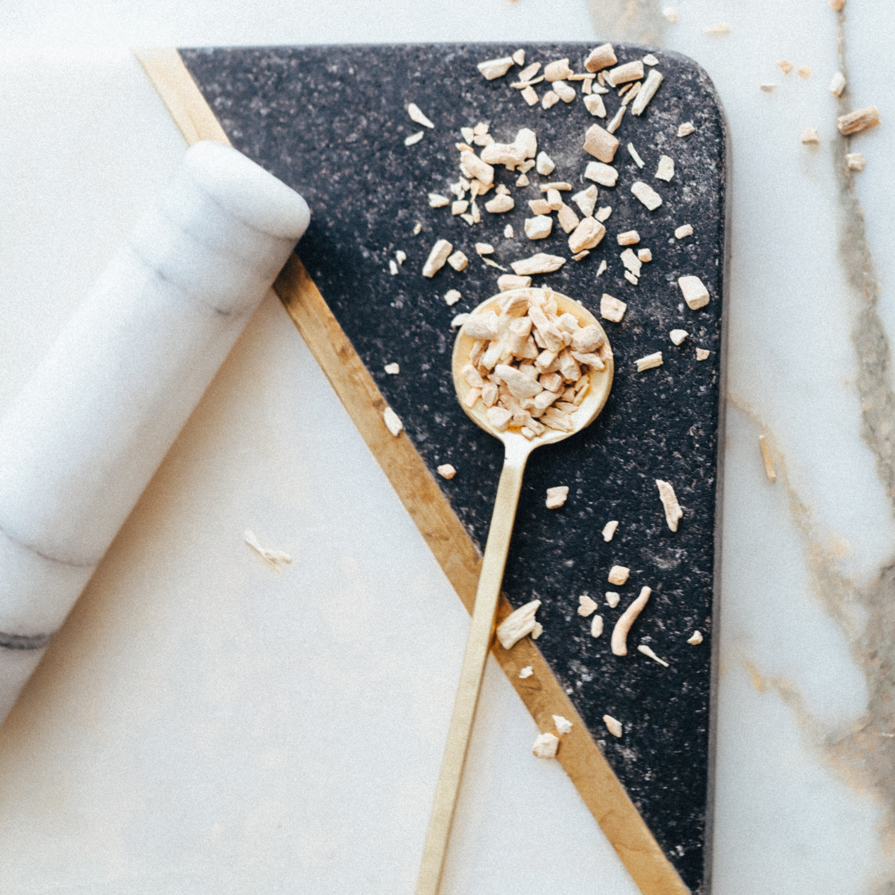 Spoon with organic ashwagandha on a dark stone surface with a marble background