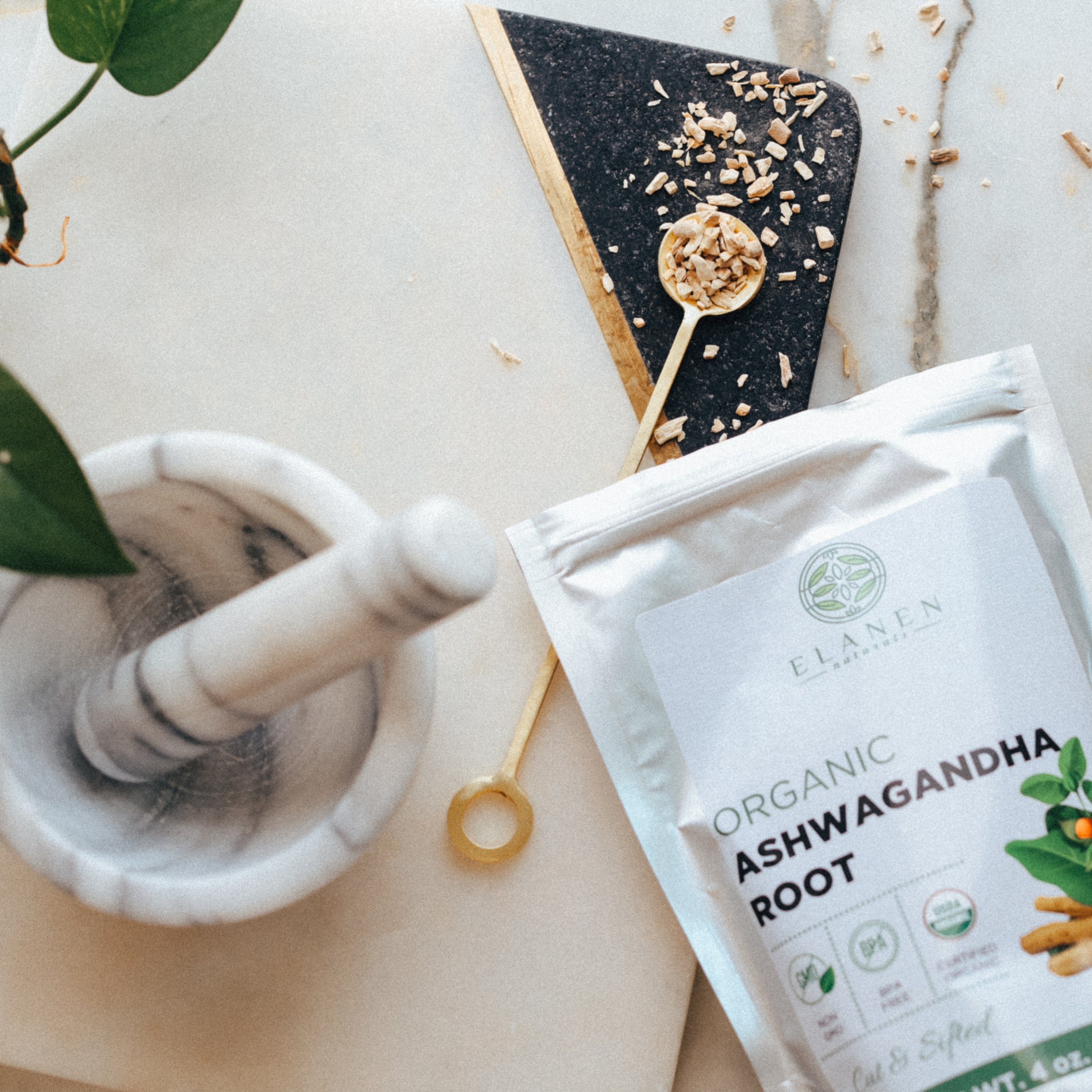 Elanen Organic Ashwagandha Root package on a marble surface with a mortar and pestle.