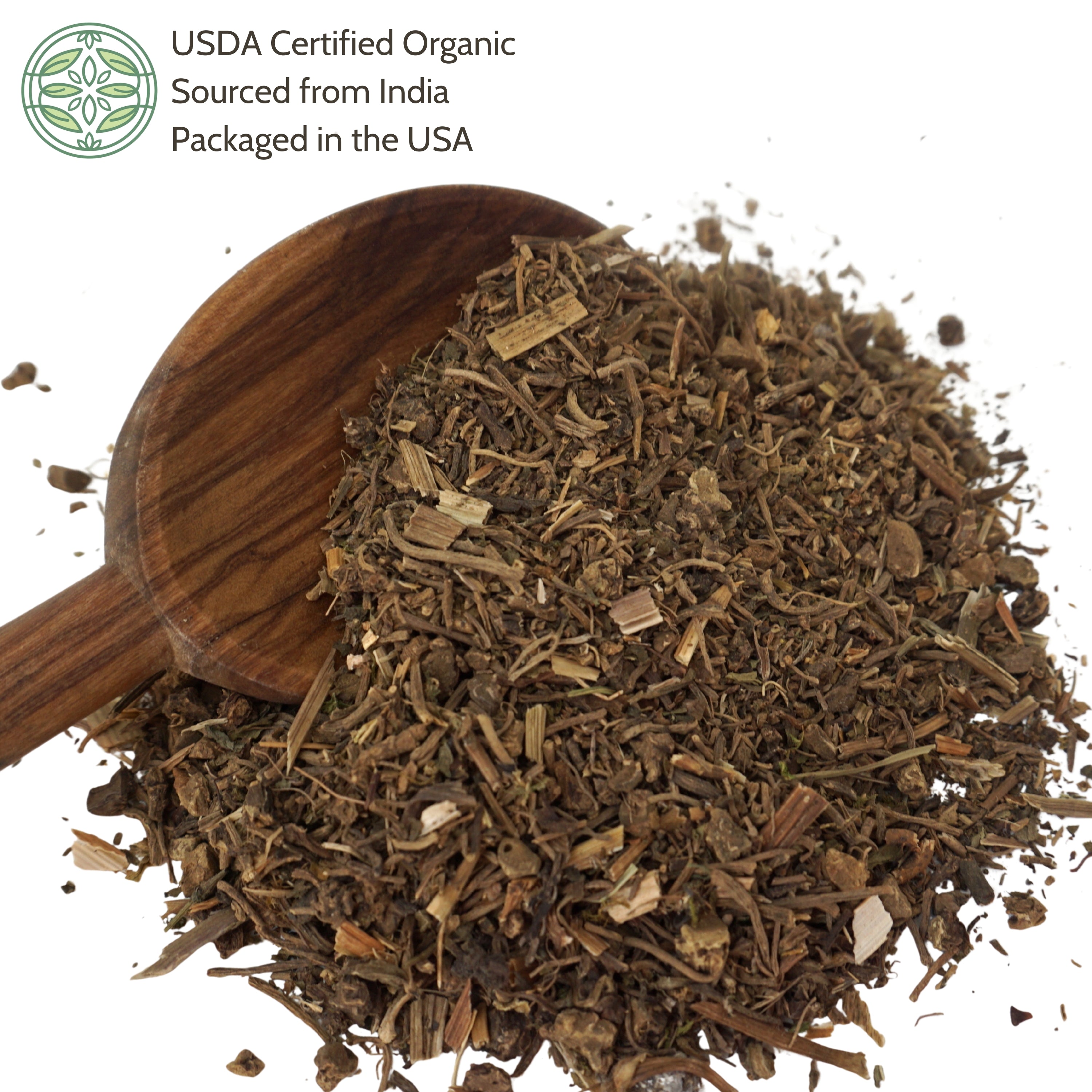 Dry valerian root with a wooden scoop on a white background.