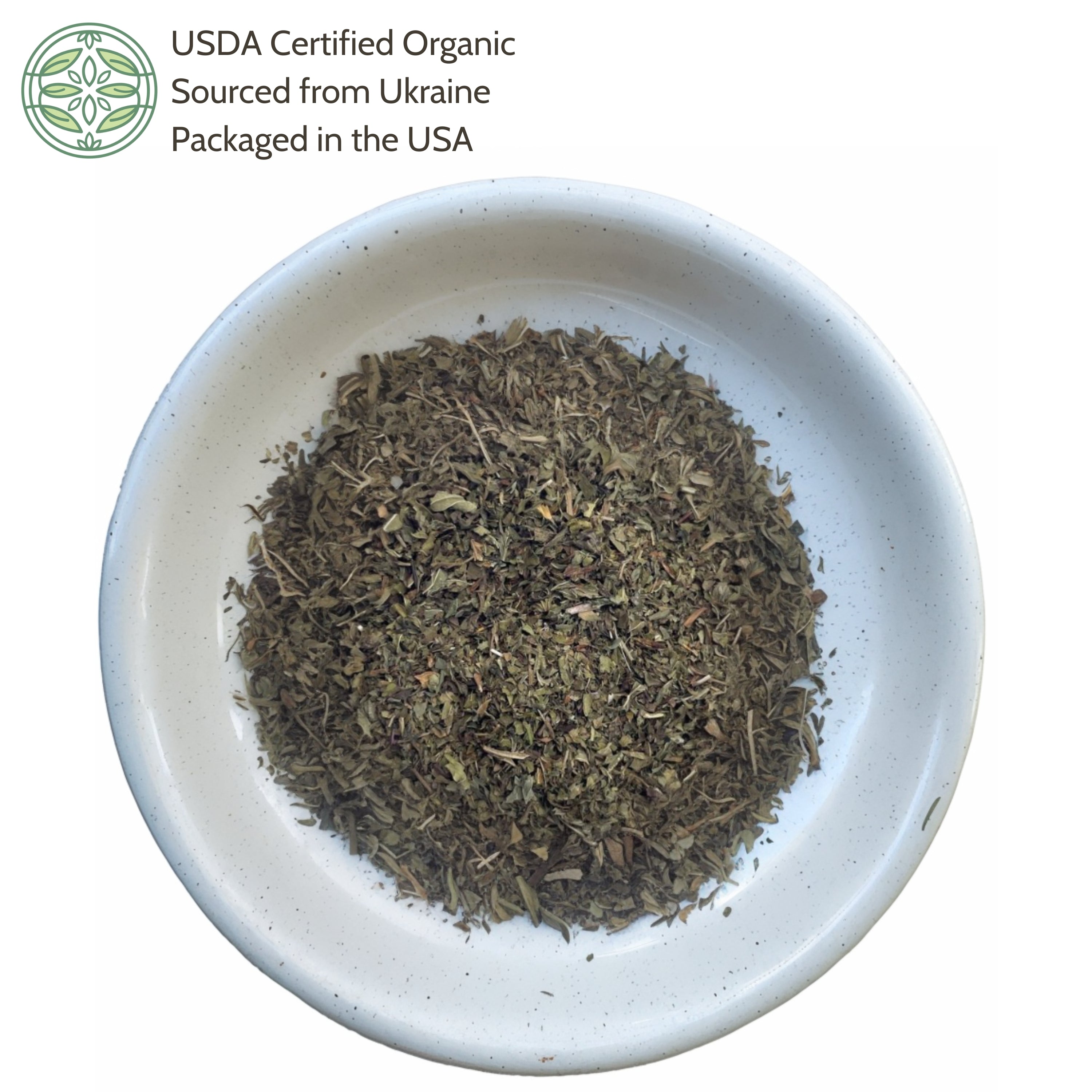 Dry herbs in a white bowl with USDA Certified Organic label on a white background
