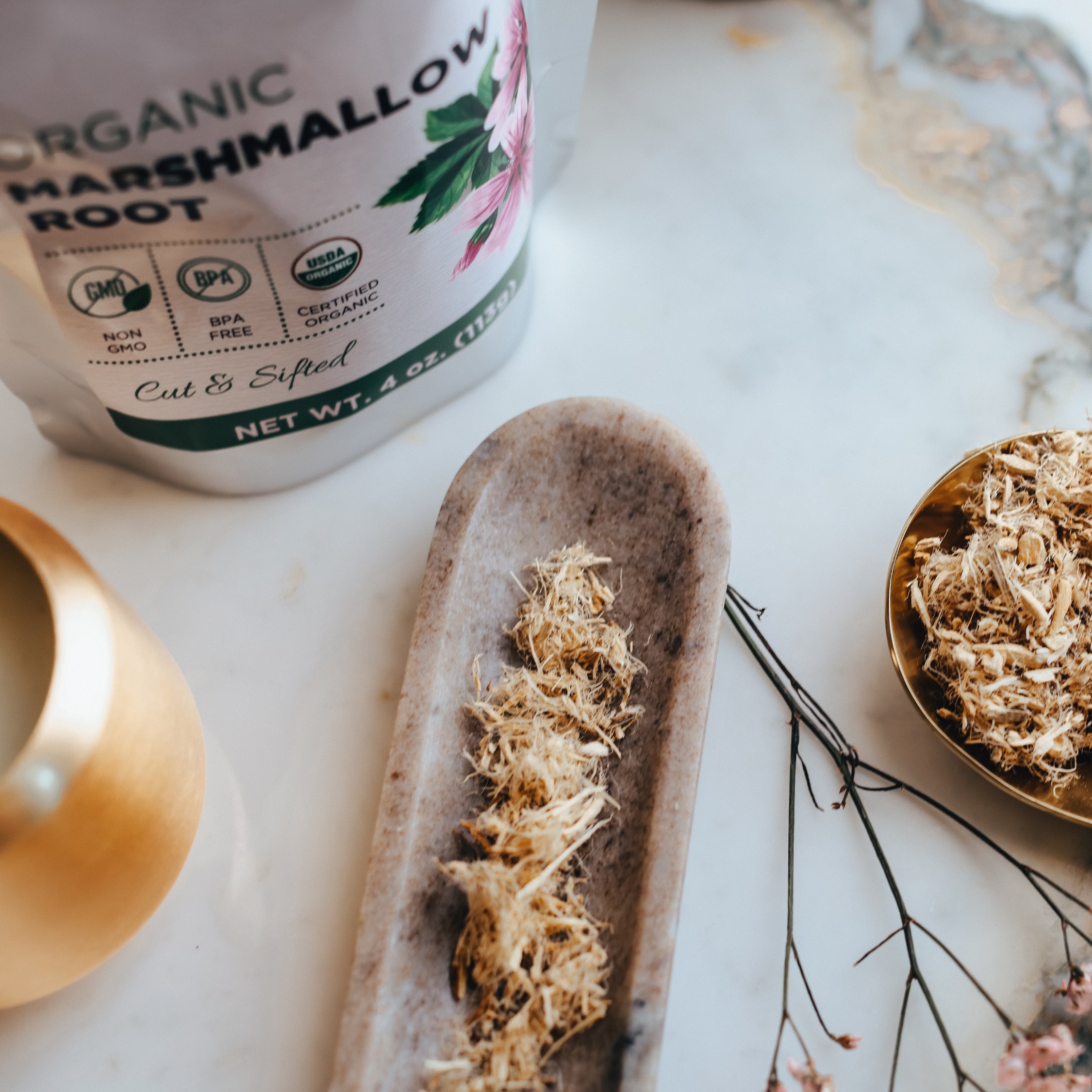 Organic marshmallow root packaging with dried root on a stone surface