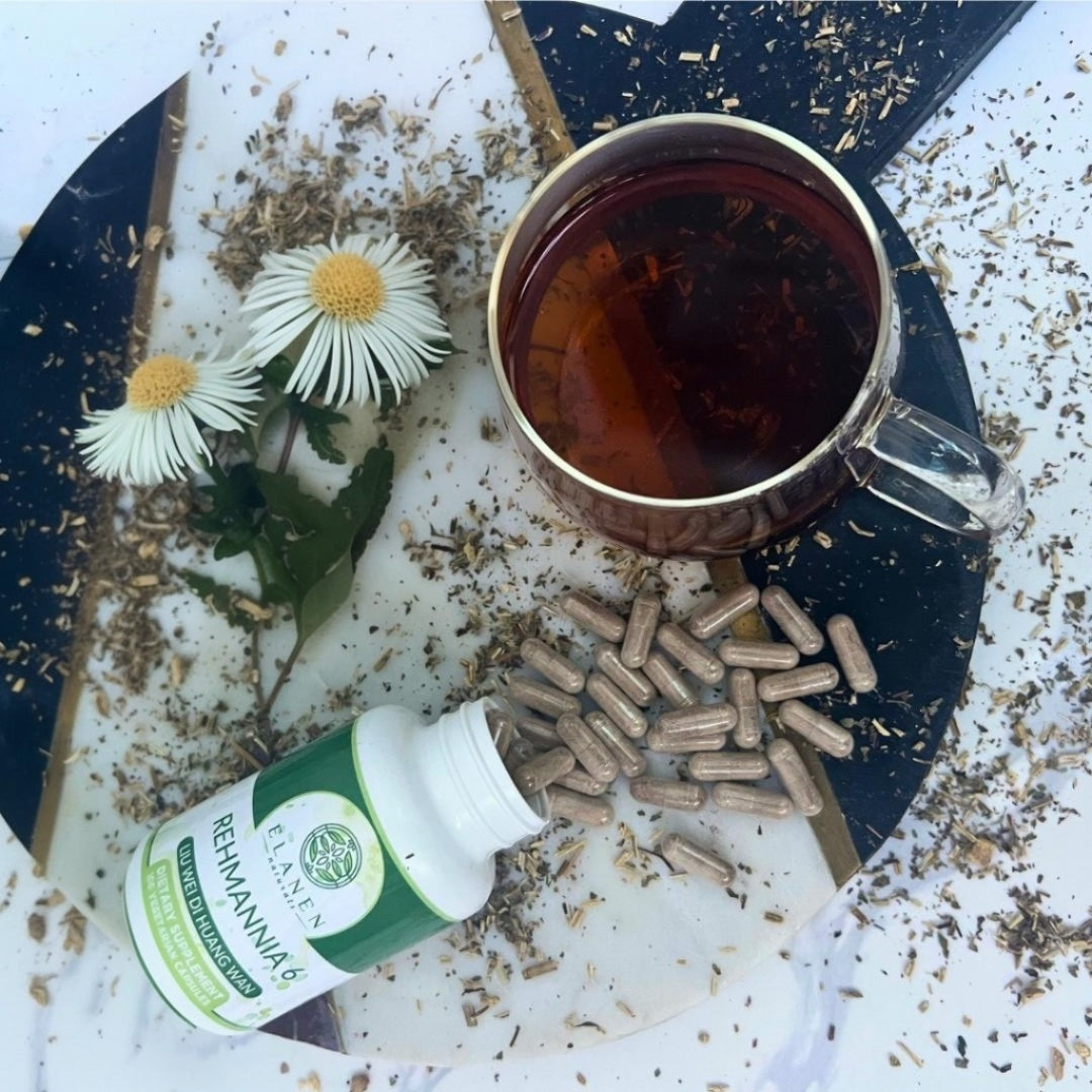 Tea with herbs, a bottle of supplements, and capsules on a textured surface.