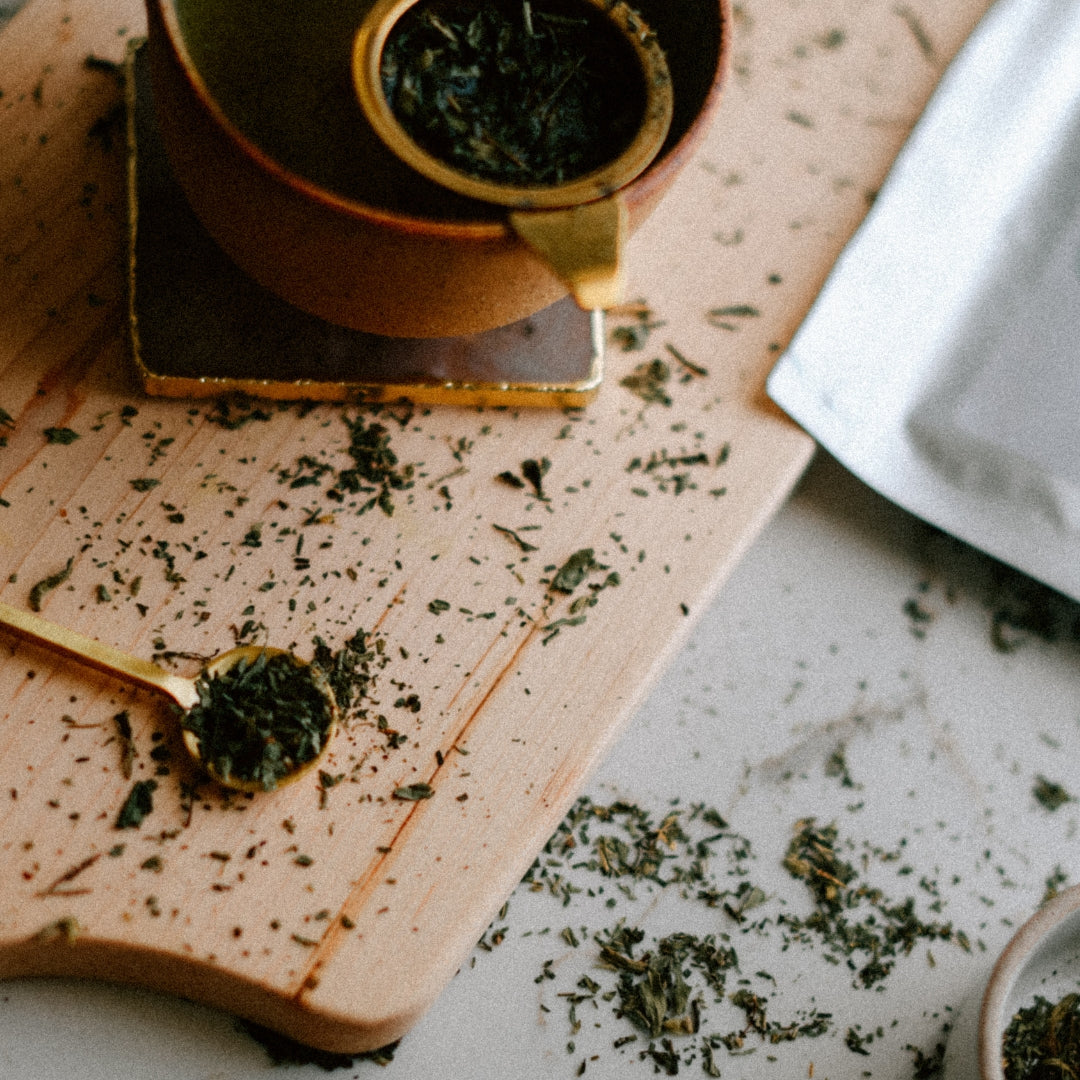 Stevia leaves on a wooden board with a teacup and spoon