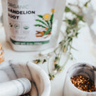 Tea packaging labeled 'Organic Dandelion Root' with a white teapot and mortar and pestle in the background.