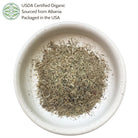 Dried herbs in a white bowl with USDA Certified Organic label on a white background