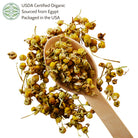 Dried chamomile on a wooden spoon with Elanen logo