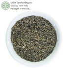 Dry herbs in a white bowl with USDA Certified Organic label on a white background