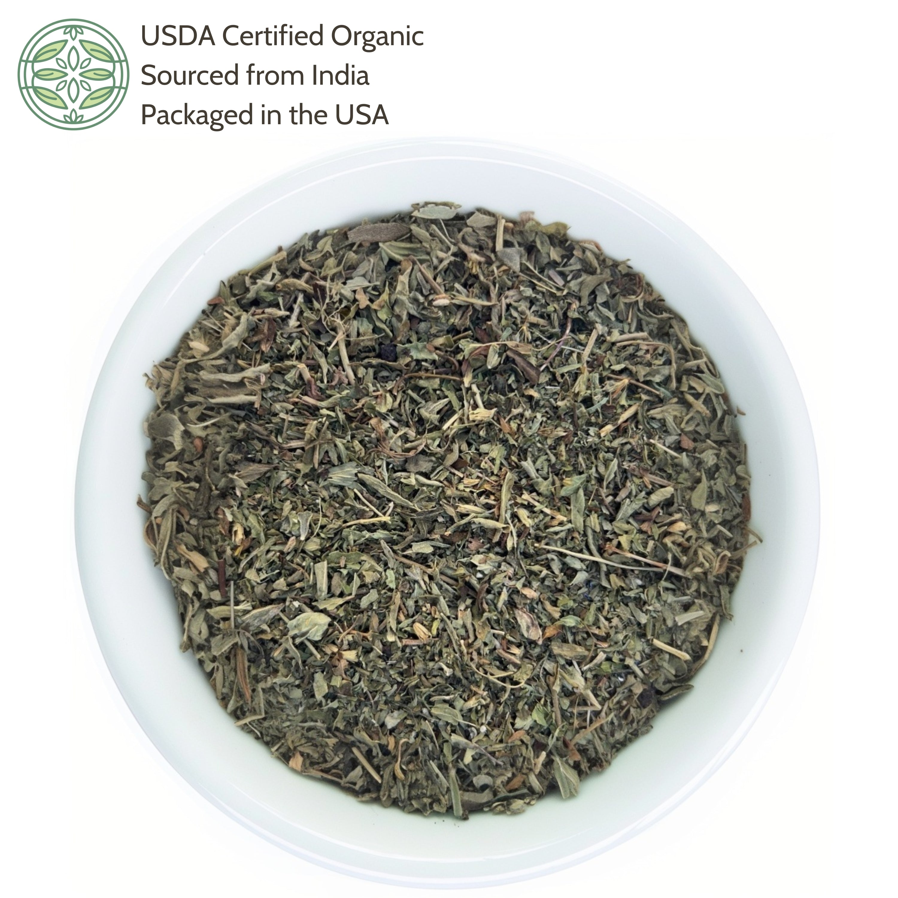 Dry herbs in a white bowl with USDA Certified Organic label on a white background