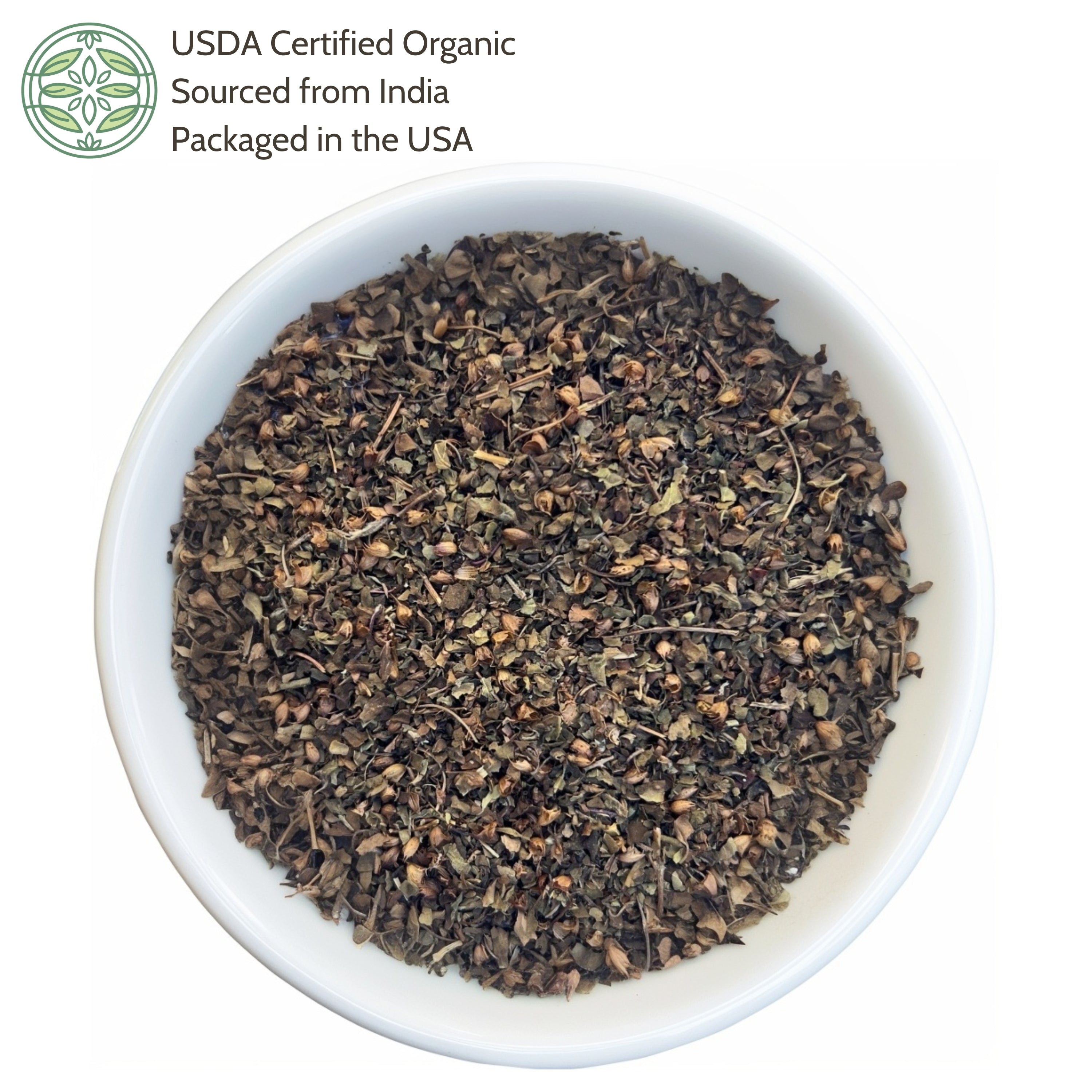 White bowl filled with organic holy basil leaves on a white background, with USDA certification label.