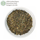Dried herbs in a white bowl with USDA Certified Organic label on a white background