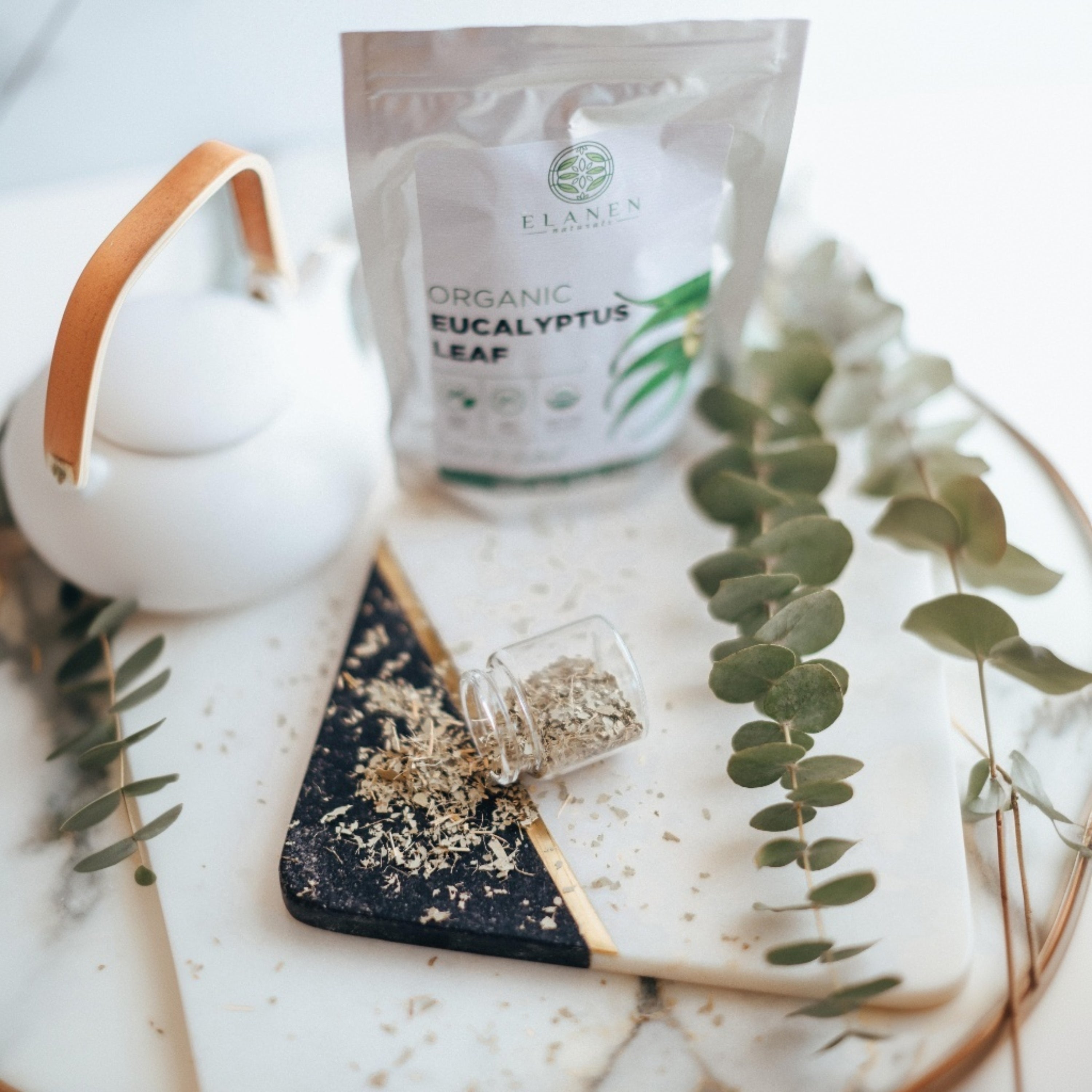 Tea set with Eucalyptus leaf packaging on a marble surface