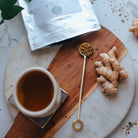 Tea cup with ginger root and tea on a marble surface