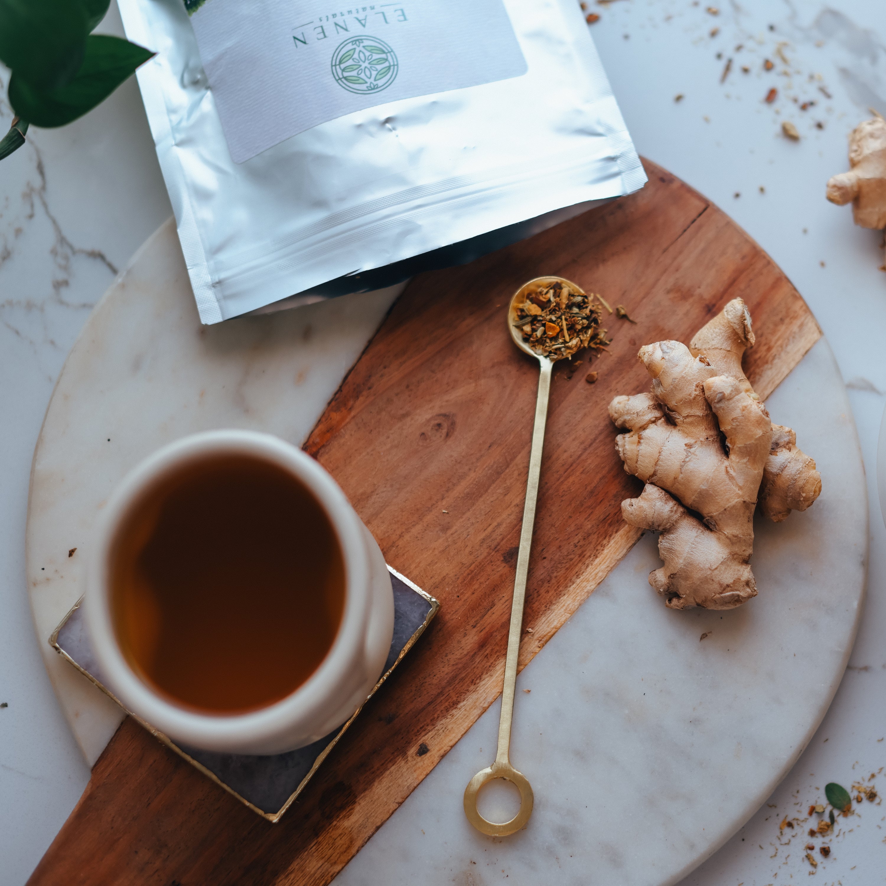 Tea cup with ginger root and tea on a marble surface
